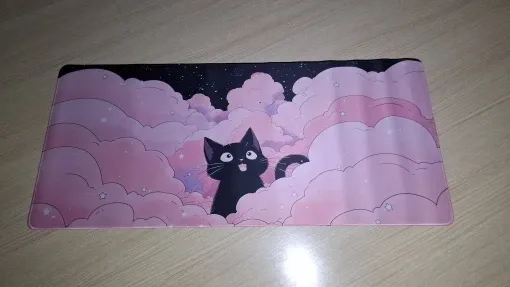 XXL black cat and pink clouds desk mat laid out flat, full view, buyer photo